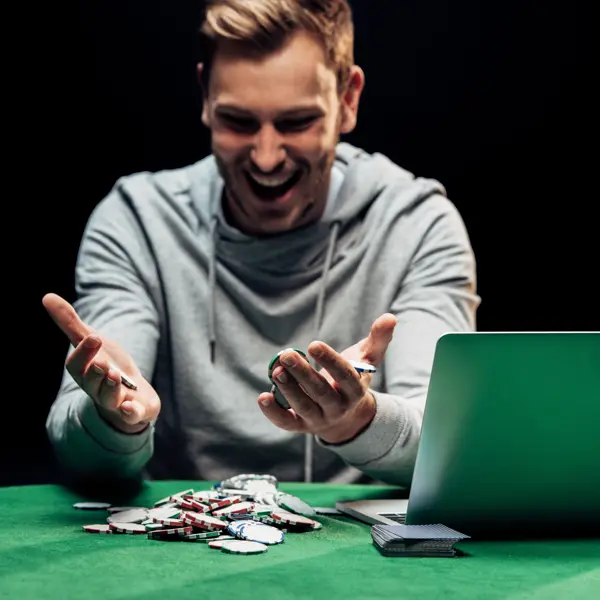 Man Playing Poker With Laptop Nearby